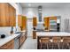 Modern kitchen featuring wood cabinets, stainless steel appliances, and a spacious island with bar seating at 12809 N 67Th St, Scottsdale, AZ 85254