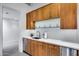 Elegant wet bar features wooden cabinets, white countertops, and glass shelves with glassware on display at 12809 N 67Th St, Scottsdale, AZ 85254