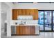 Stylish wet bar featuring custom wood cabinetry, quartz countertops, and stainless-steel appliances for easy entertaining at 12809 N 67Th St, Scottsdale, AZ 85254