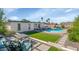 Backyard featuring pool, outdoor kitchen, manicured lawn, and seating areas at 15028 N 9Th St, Phoenix, AZ 85022