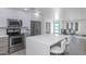 Bright kitchen features stainless appliances, modern cabinetry, and a large island with seating at 15028 N 9Th St, Phoenix, AZ 85022