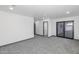 Spacious living room featuring sliding glass doors and neutral-colored walls with carpet at 15028 N 9Th St, Phoenix, AZ 85022