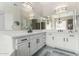 Bright bathroom featuring a double vanity with white cabinets, stone countertops, modern fixtures, and an elegant chandelier at 15664 W Vernon Ave, Goodyear, AZ 85395