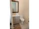 Powder room features a modern vanity, a decorative mirror, and a toilet at 15664 W Vernon Ave, Goodyear, AZ 85395