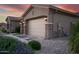 Close-up of a three-car garage with beautiful stone accents and manicured landscaping at 15664 W Vernon Ave, Goodyear, AZ 85395