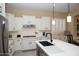 Bright kitchen with white cabinets, stainless steel appliances, quartz countertops, and stylish lighting at 15664 W Vernon Ave, Goodyear, AZ 85395