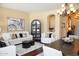 Bright living room featuring a white sofa set with stylish pillows and a modern display cabinet at 15664 W Vernon Ave, Goodyear, AZ 85395