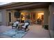 Inviting covered patio with comfortable seating, an outdoor television, and views of the beautifully decorated home interior at 15664 W Vernon Ave, Goodyear, AZ 85395
