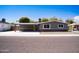 Attractive exterior view shows a single story house with attached carport and landscaped front at 2035 W Claremont St, Phoenix, AZ 85015