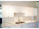 Kitchen with white cabinets, quartz counters, a stainless steel sink, and modern fixtures at 2035 W Claremont St, Phoenix, AZ 85015