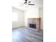 Bright living room featuring a brick fireplace, light gray floors, and a large window at 2035 W Claremont St, Phoenix, AZ 85015