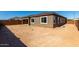 Spacious dirt backyard with covered patio and expansive windows at 24054 N 171St Dr, Surprise, AZ 85387