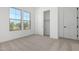 Bright bedroom featuring two windows, neutral carpet, and a spacious closet at 24054 N 171St Dr, Surprise, AZ 85387