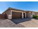 Attractive home with a three-car garage, paved driveway, and beautifully landscaped front yard at 24054 N 171St Dr, Surprise, AZ 85387