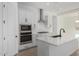 This modern kitchen boasts white cabinetry, an island with sink, and stainless steel appliances at 24054 N 171St Dr, Surprise, AZ 85387