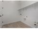 A well-lit laundry room with tile floors, overhead shelving, and essential hookups at 24054 N 171St Dr, Surprise, AZ 85387