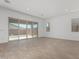 Bright, empty living room with tile flooring and sliding glass doors to the backyard at 24054 N 171St Dr, Surprise, AZ 85387