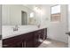 Bright bathroom featuring a double sink vanity with modern fixtures and a large mirror at 24078 N 171St Dr, Surprise, AZ 85387