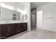 Bathroom with double sinks, modern fixtures, and a glass-enclosed shower at 24078 N 171St Dr, Surprise, AZ 85387