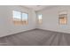 A bright bedroom featuring a large window and neutral carpeting at 24078 N 171St Dr, Surprise, AZ 85387
