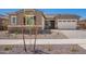 Beautiful front yard featuring mature landscaping, a stone facade, and three-car garage at 24078 N 171St Dr, Surprise, AZ 85387