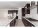 Modern kitchen featuring dark cabinetry, a large island, and stainless steel appliances, perfect for cooking at 24078 N 171St Dr, Surprise, AZ 85387