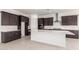 Modern kitchen featuring dark cabinetry, a large island, and stainless steel appliances, perfect for cooking at 24078 N 171St Dr, Surprise, AZ 85387