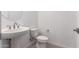 Clean powder room with a pedestal sink, a round mirror, modern fixtures, and a toilet at 24078 N 171St Dr, Surprise, AZ 85387