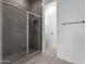 Modern glass-enclosed shower with a dark tiled surround and built-in niche at 24078 N 171St Dr, Surprise, AZ 85387