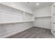 Spacious walk-in closet with carpet flooring and custom shelving, offering ample storage at 24078 N 171St Dr, Surprise, AZ 85387