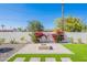 Backyard features a brick fire pit, brick and gravel pavers, and a white brick wall with floral bushes at 3010 E Glenrosa Ave, Phoenix, AZ 85016