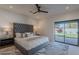 This primary bedroom boasts a tufted headboard, stylish ceiling fan, and sliding glass door to the yard at 3010 E Glenrosa Ave, Phoenix, AZ 85016