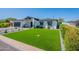 Charming single-story home boasts a lush green lawn and modern desert landscaping at 3010 E Glenrosa Ave, Phoenix, AZ 85016
