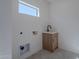 Bright laundry room with herringbone tile, and wooden sink cabinet at 3010 E Glenrosa Ave, Phoenix, AZ 85016