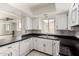 Modern kitchen with white cabinetry, black countertops and a window view at 7061 E Broadway Rd # 48, Mesa, AZ 85208