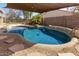 Backyard pool featuring custom rock accents and a shaded cover, perfect for enjoying sunny days outdoors at 8757 W El Caminito Dr, Peoria, AZ 85345