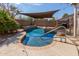 Inviting pool with rock features and shade cover, perfect for relaxation and outdoor enjoyment at 8757 W El Caminito Dr, Peoria, AZ 85345