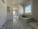 Elegant bathroom with a soaking tub, tiled shower, and patterned tile flooring at 11422 E Utah Ave, Mesa, AZ 85212