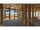 The interior framing of a house exhibits the window placements, structural framework, and the unfinished concrete floor at 11422 E Utah Ave, Mesa, AZ 85212