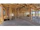 The unfinished interior showcases exposed wooden framework, utility lines, and a seamless concrete floor at 11422 E Utah Ave, Mesa, AZ 85212