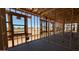 A home's interior framing displays structural elements, window openings, and the unfinished concrete floor at 11422 E Utah Ave, Mesa, AZ 85212