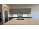Bright kitchen features gray cabinets, quartz countertops, and stainless steel appliances at 11422 E Utah Ave, Mesa, AZ 85212