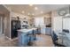 Well-lit kitchen featuring gray cabinets, stainless steel appliances, an island, and a dining area at 1282 W Kesler Ln, Chandler, AZ 85224