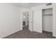 A bedroom with neutral walls, plush carpet, closet, and door to the en suite bathroom at 12825 W Virginia Ave, Avondale, AZ 85392