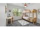 Well-lit bedroom with a bunk bed, desk, and a large window showing green outdoor views at 12825 W Virginia Ave, Avondale, AZ 85392