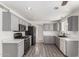 Updated kitchen with grey cabinets, stainless steel appliances, and laminate floors at 12825 W Virginia Ave, Avondale, AZ 85392