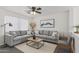 Cozy living room featuring an L-shaped couch and a natural light from a large window at 12825 W Virginia Ave, Avondale, AZ 85392