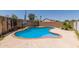 Backyard pool with brick trim, a basketball hoop, and enclosed by block and wood fencing at 12825 W Virginia Ave, Avondale, AZ 85392