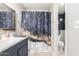 Bathroom featuring updated vanity, framed mirror, and modern shower curtain at 16496 N 68Th Ave, Peoria, AZ 85382