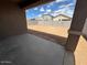 A view of the backyard with a concrete slab patio at 17016 W Cavedale Dr, Surprise, AZ 85387